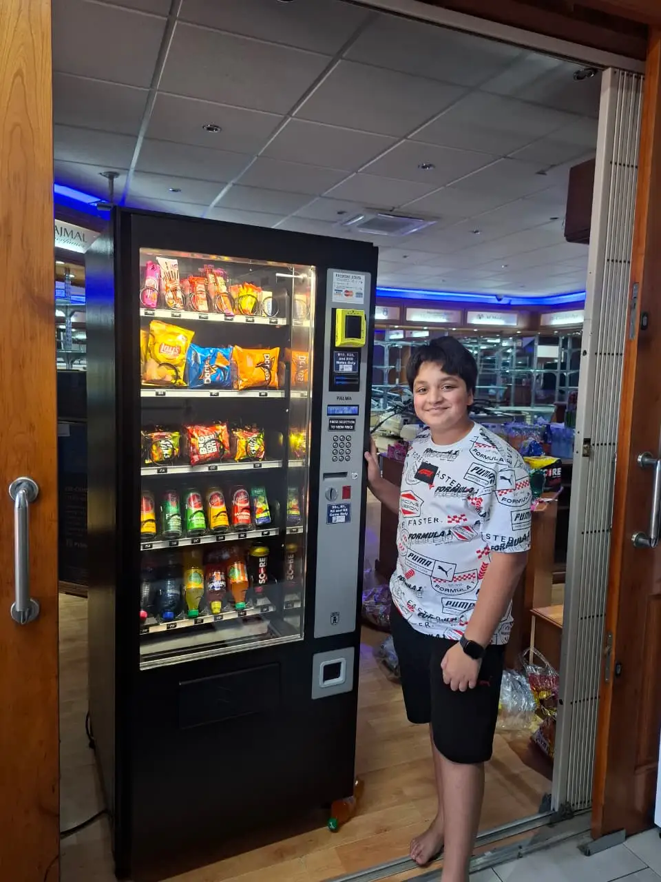 A young entrepreneur standing with his first vending machine