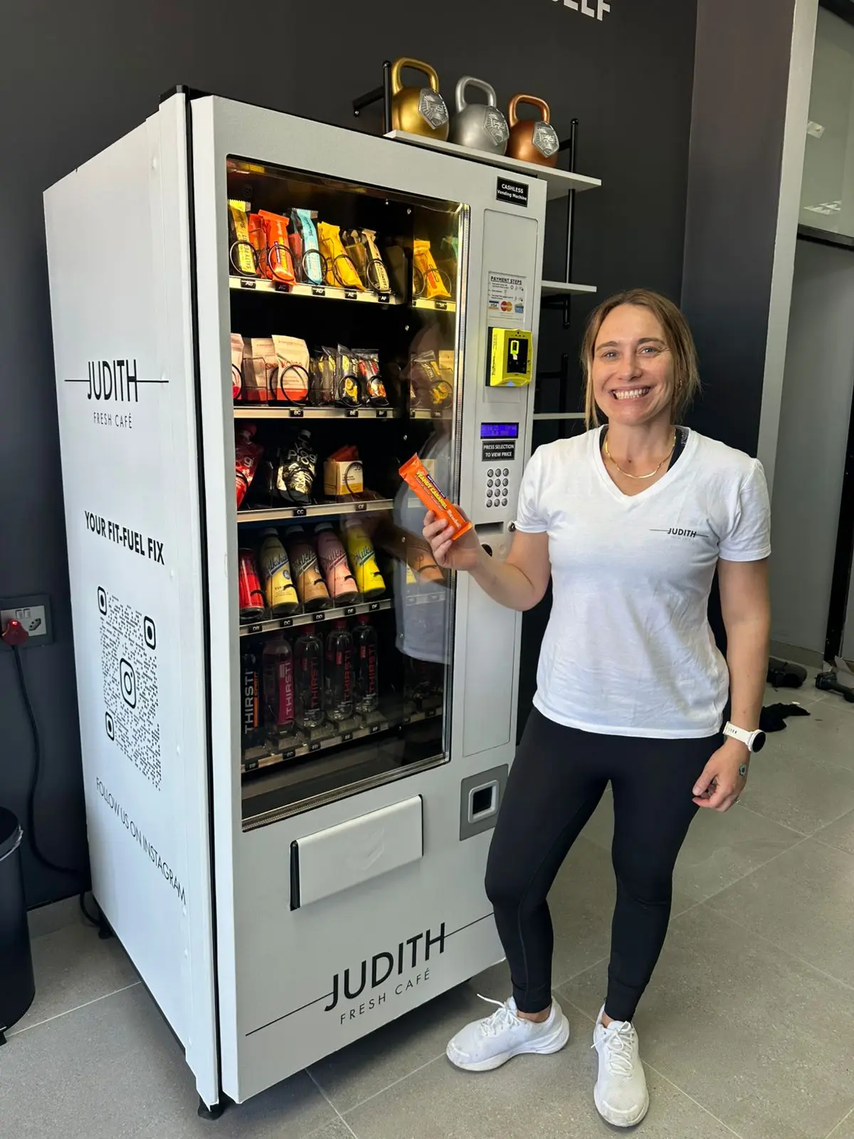 A client beside a branded healthy-vending machine stocked with low-carb options