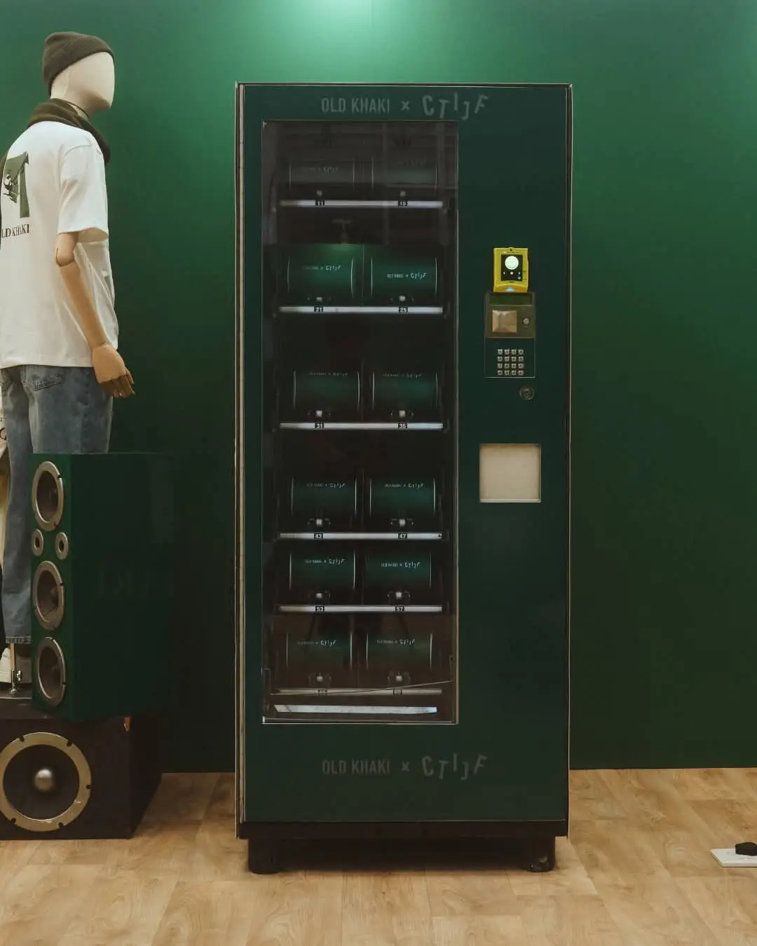 A vending machine wrapped in Old Khaki branding, dispensing T-shirts at an activation