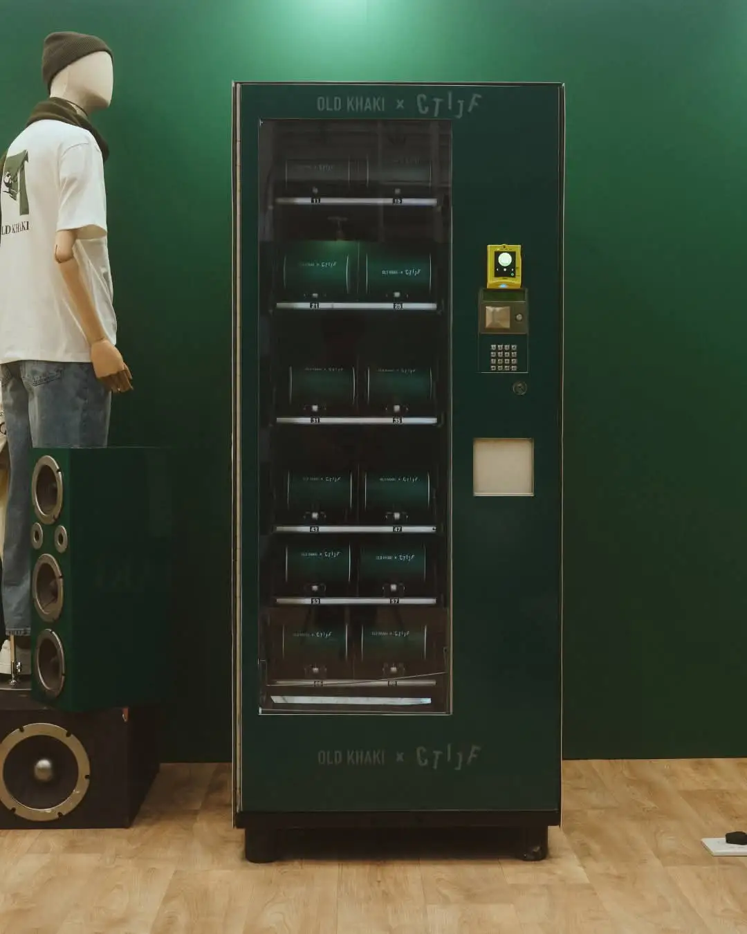 A vending machine wrapped in Old Khaki branding, dispensing T-shirts at an activation