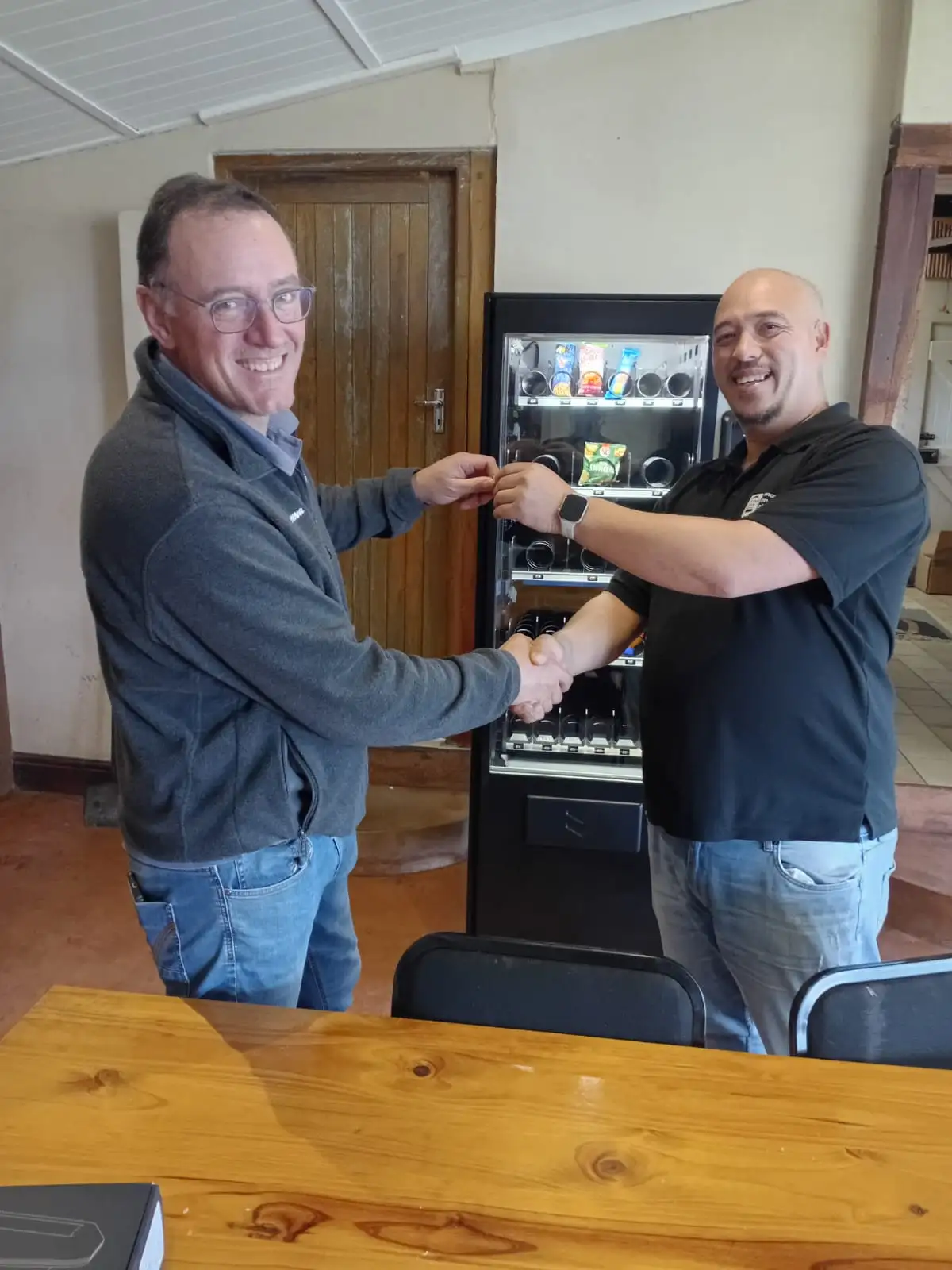 A client shaking hands beside their newly installed Palma Hz70 vending machine