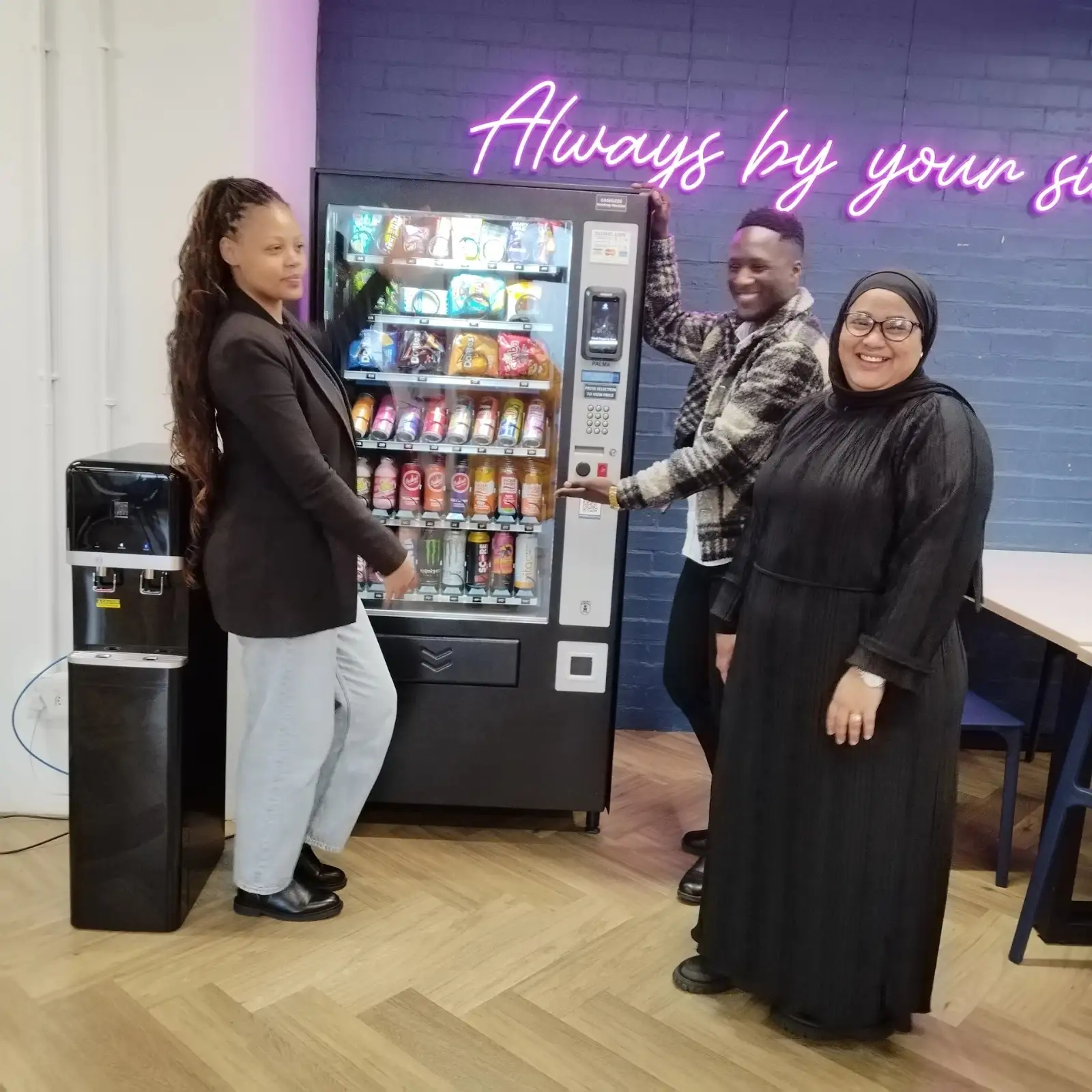 Clients standing with a newly installed cashless vending machine at their workplace