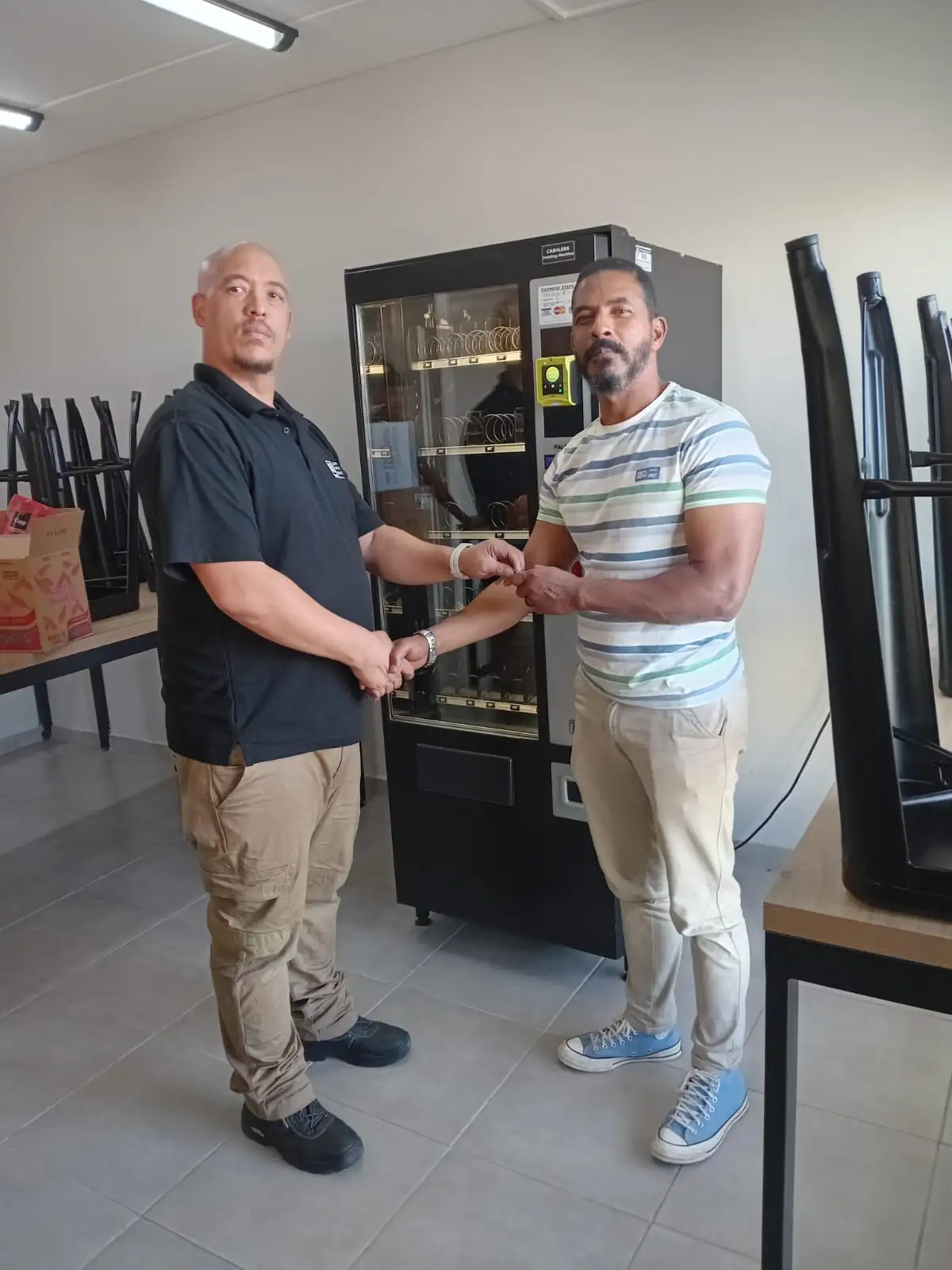 An IVS team member handing over the keys of a new vending machine to a client