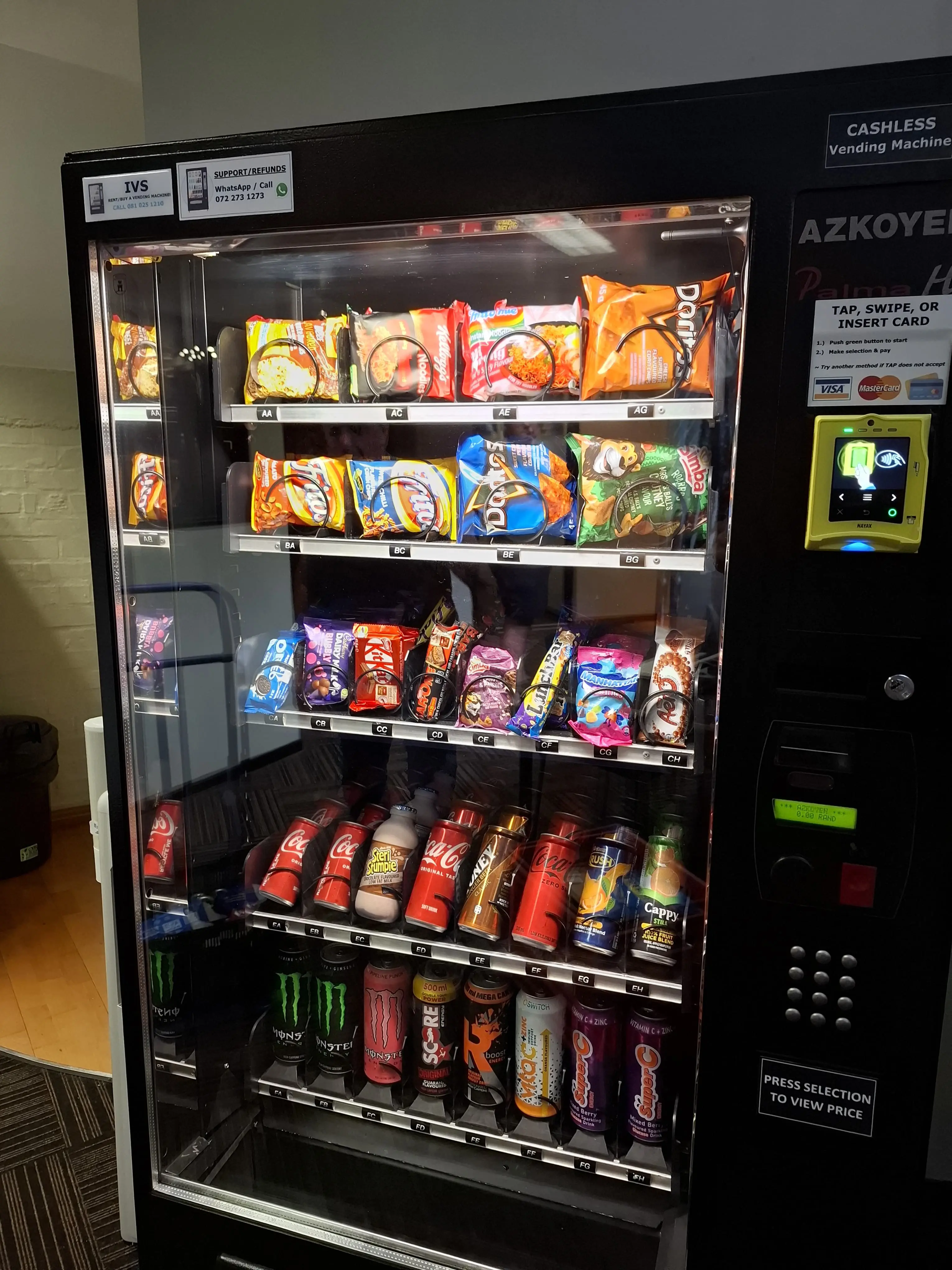 Vending machine shelves stocked with snacks, chocolate, crisps and cold drinks